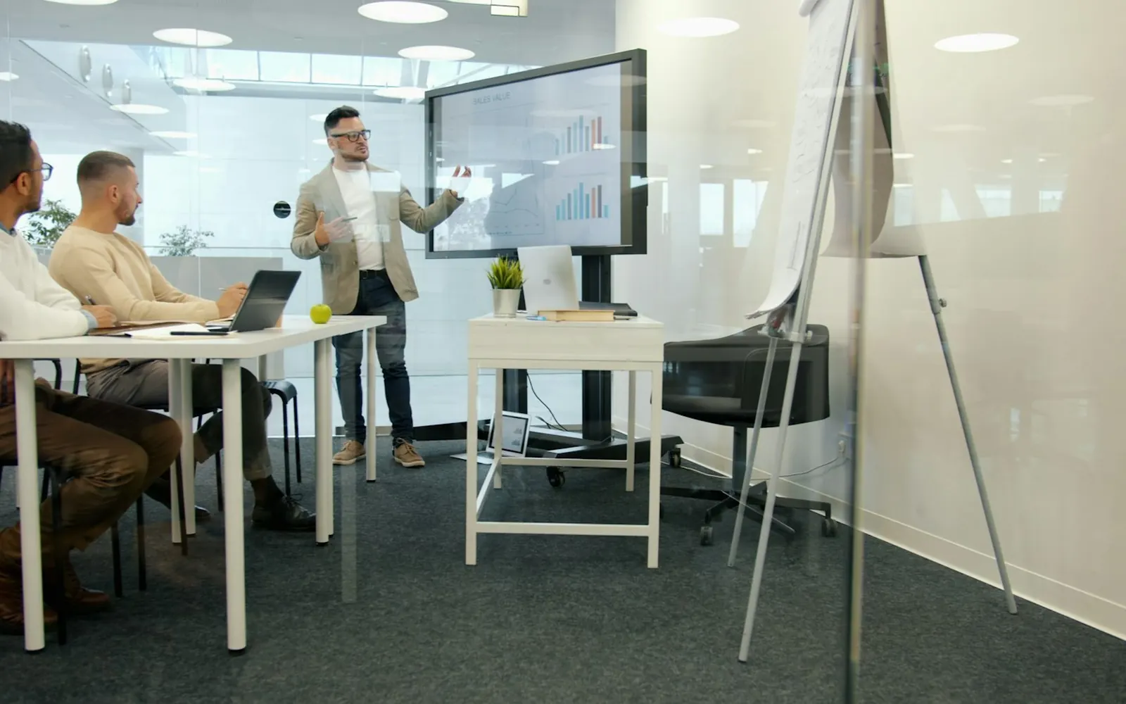 A man presenting to a group of colleagues in a bright, modern office