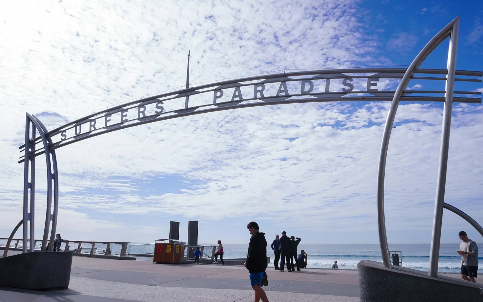 Crowds strolling past the Surfers Paradise beachfront sign, a popular backdrop for Gold Coast social content