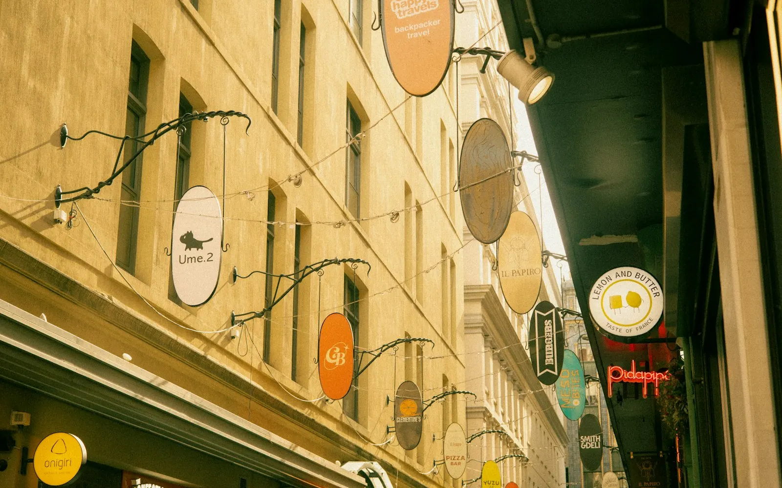 Narrow Melbourne CBD laneway with cafe and shop signs hanging above the walkway