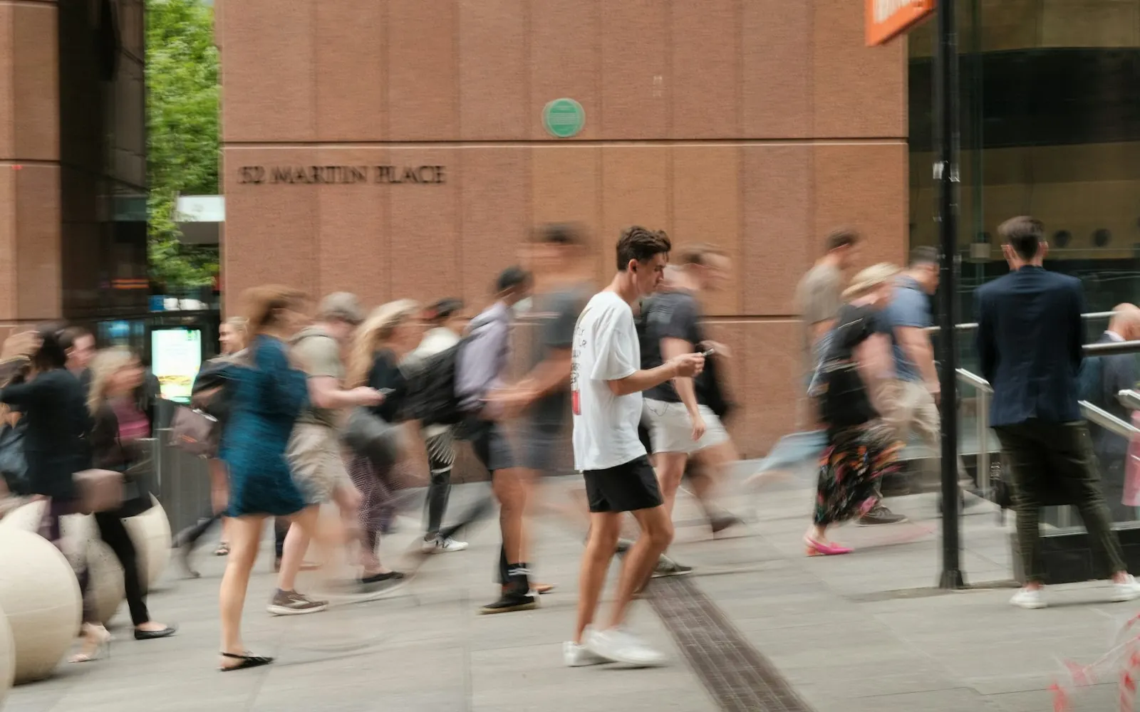 Pedestrians walking briskly along a crowded Sydney CBD footpath on a weekday