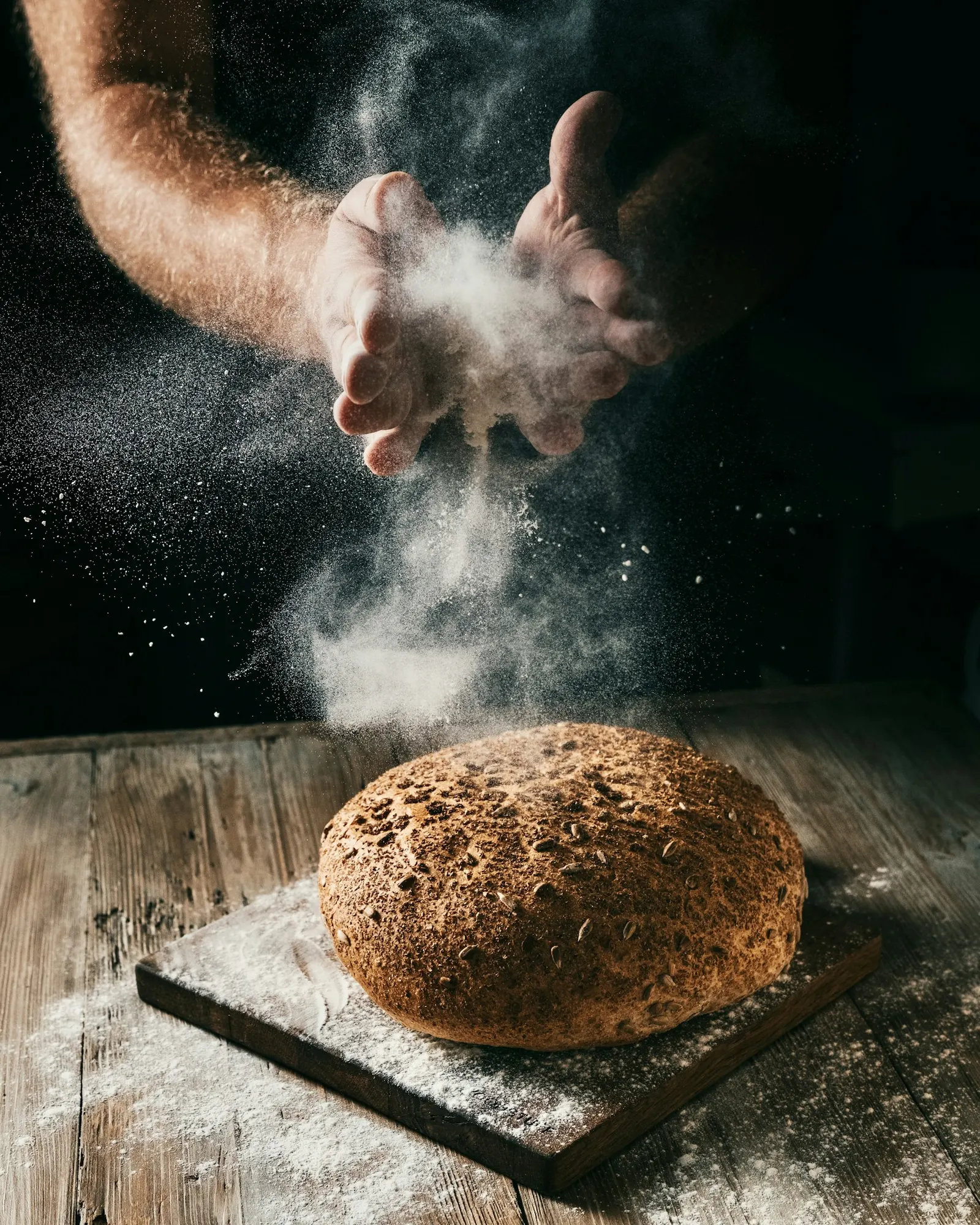A loaf of bread being dusted with flour