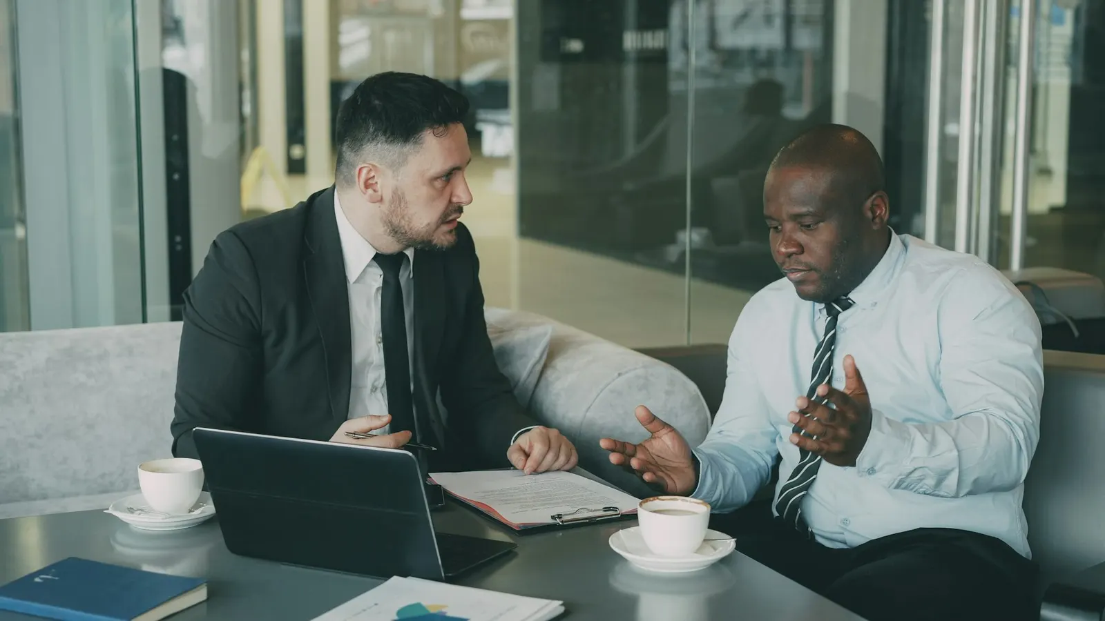 Two professionals discussing documents at a table