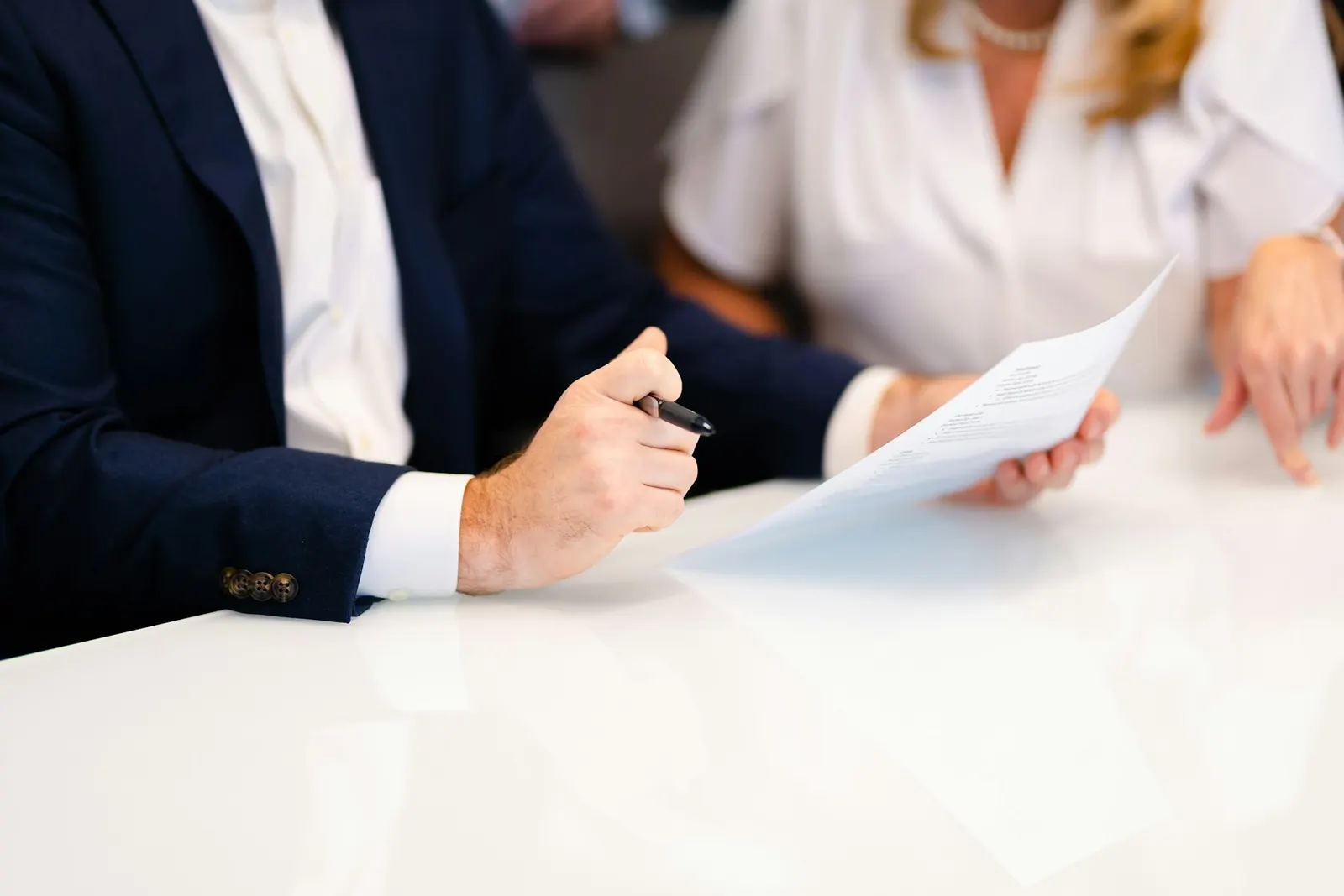 Two people reviewing paperwork together at a white table