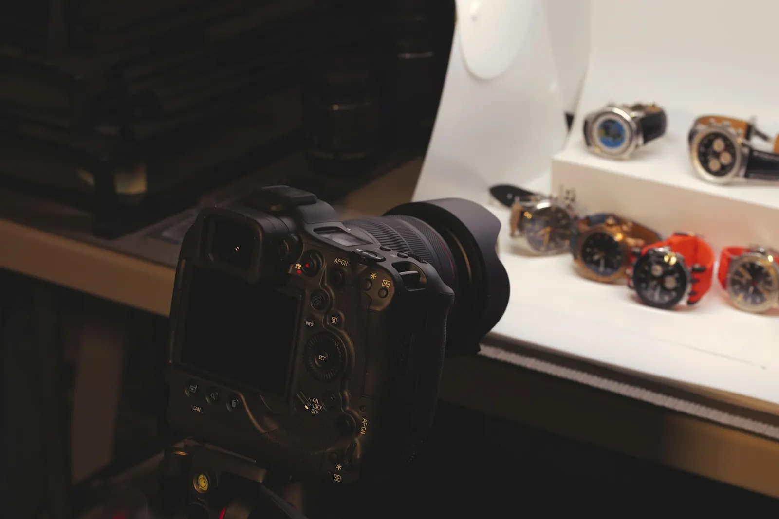 Camera on a tripod photographing a row of wristwatches